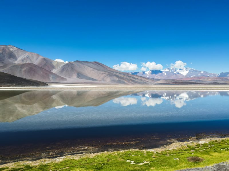 Laguna espejada con cerros nevados