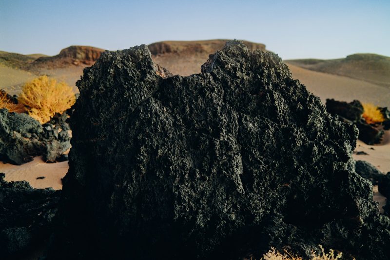 Roca volcánica negra y pastos dorados
